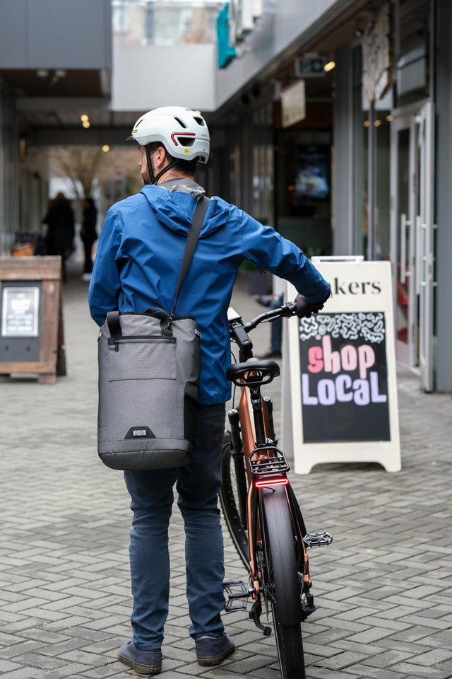 Two Wheel Gear Grey Solo Market Pannier being carried with shoulder strap at outdoor market