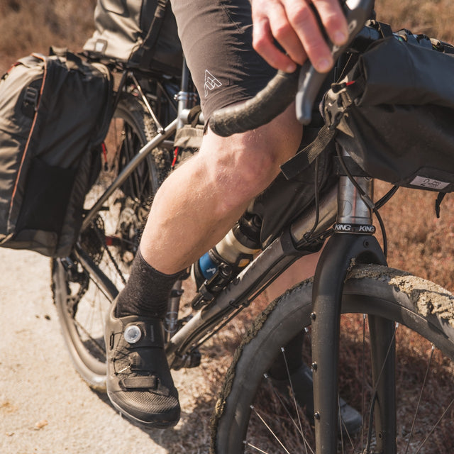 Two Wheel Gear - Man pedals with collection of bike bags on bicycle